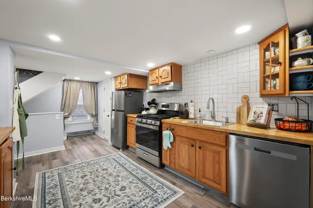 a kitchen with stainless steel appliances granite countertop a refrigerator a sink a stove a microwave a counter space and cabinets