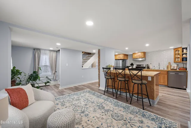 a living room with furniture a wooden floor and a kitchen view