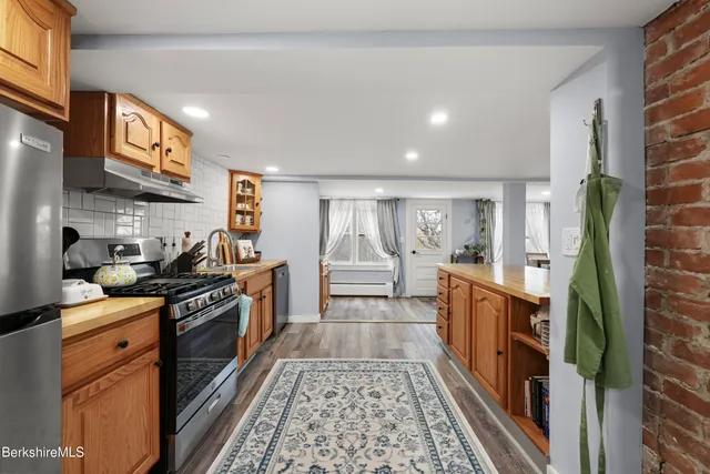 a kitchen with stainless steel appliances granite countertop a stove a sink and a refrigerator