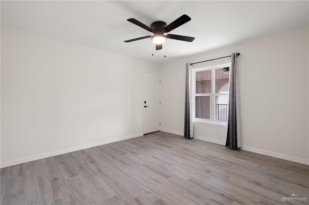 400 Taurus Street Mission, TX 78572 - Photo 11 of 18 an empty room with wooden floor and ceiling fan
