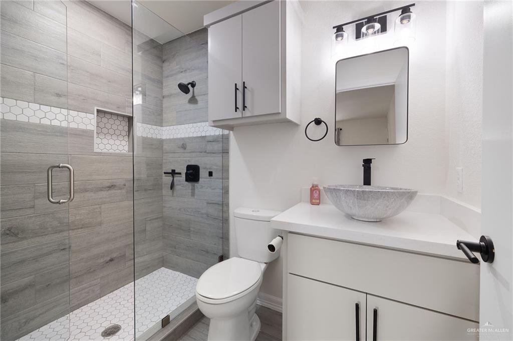 400 Taurus Street Mission, TX 78572 - Photo 12 of 18 a bathroom with a granite countertop sink a toilet and mirror