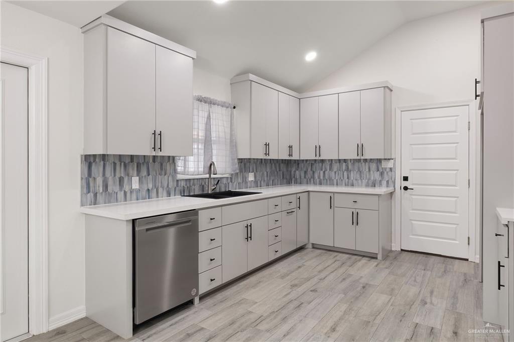400 Taurus Street Mission, TX 78572 - Photo 9 of 18 a kitchen with white cabinets and sink
