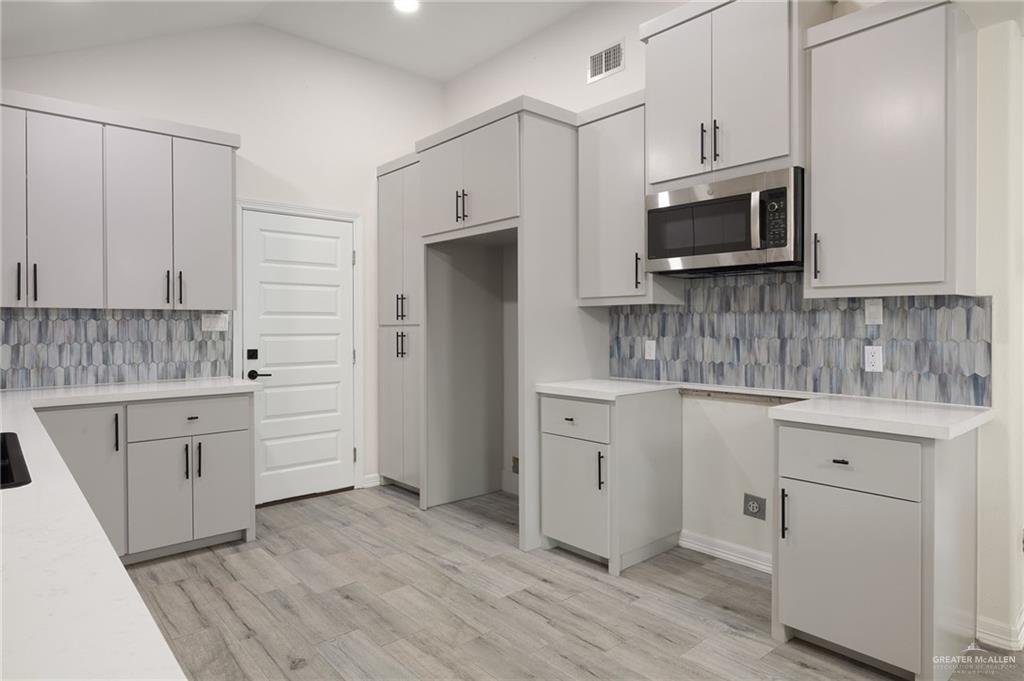 400 Taurus Street Mission, TX 78572 - Photo 10 of 18 a kitchen with white cabinets appliances and sink