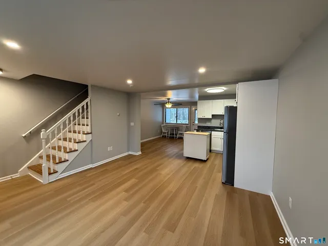 a view of a kitchen with furniture and wooden floor