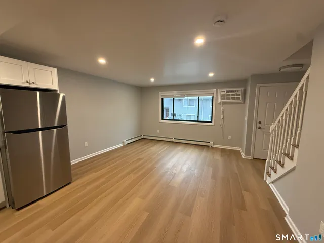 an empty room with wooden floor and a window