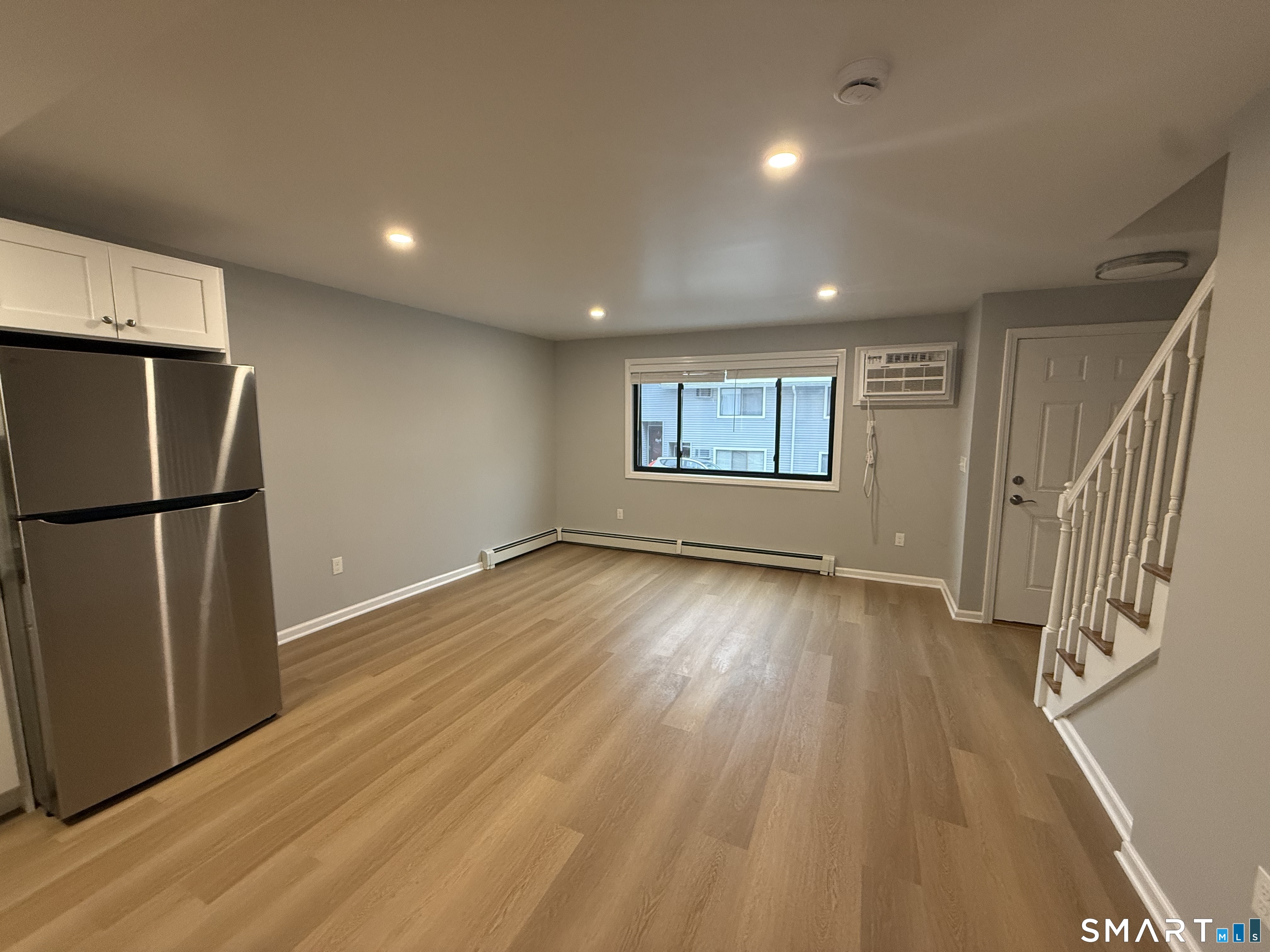 292 Meridian Street, Unit K Groton, CT 06340 - Photo 4 of 20 an empty room with wooden floor and a window