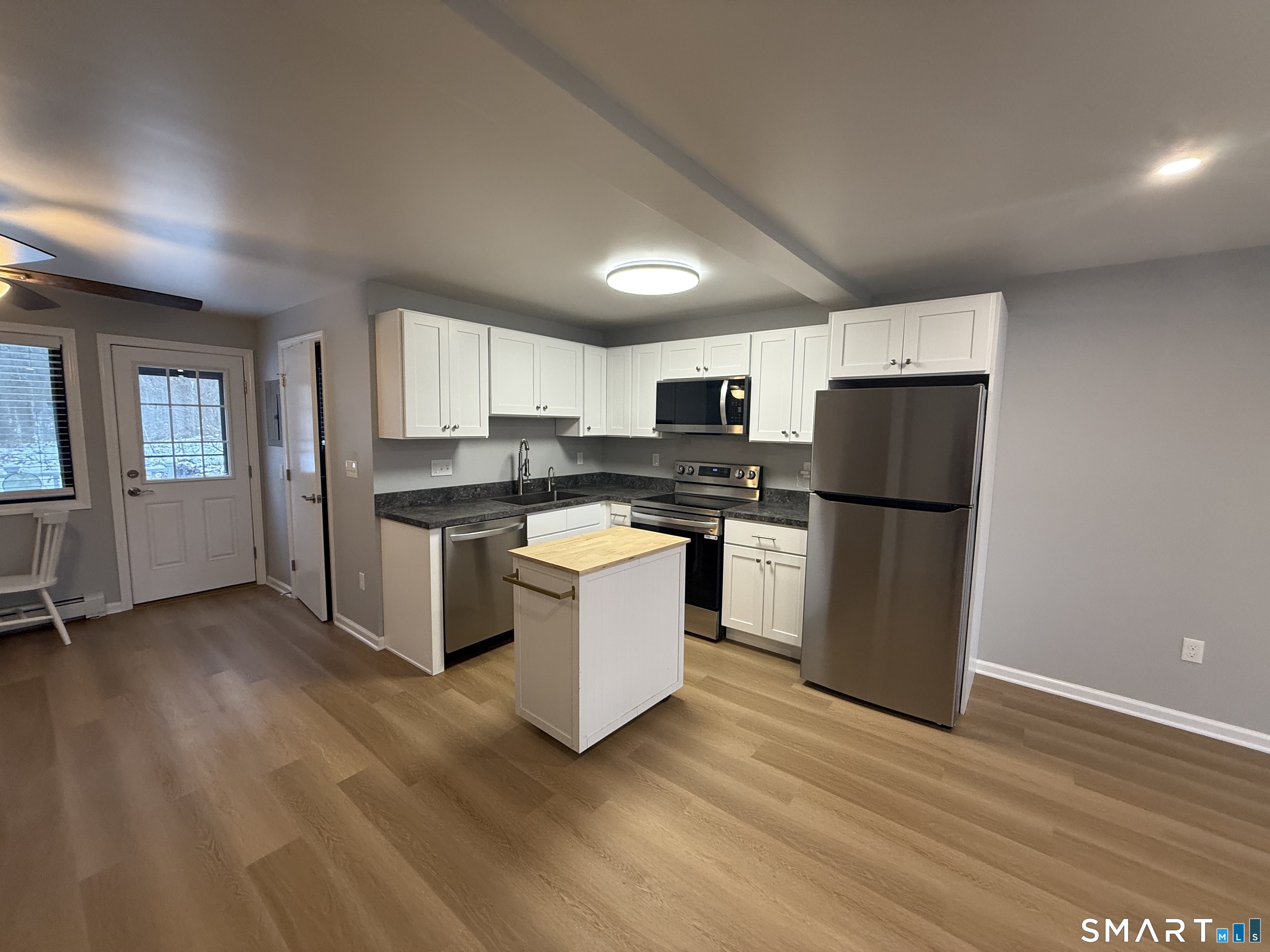 292 Meridian Street, Unit K Groton, CT 06340 - Photo 9 of 20 a kitchen with granite countertop a refrigerator and a stove top oven