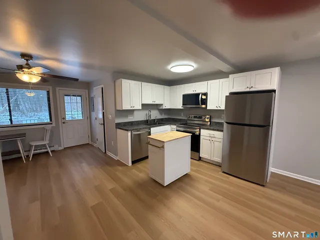 a kitchen with a refrigerator and a stove top oven
