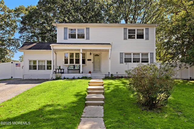 a front view of a house with a yard and potted plants