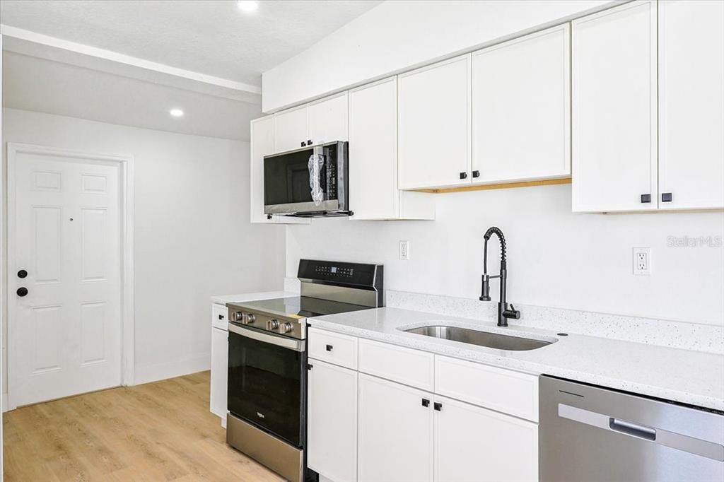 4061 Ferrow Street Orlando, FL 32811 - Photo 12 of 31 a kitchen with sink a microwave and cabinets