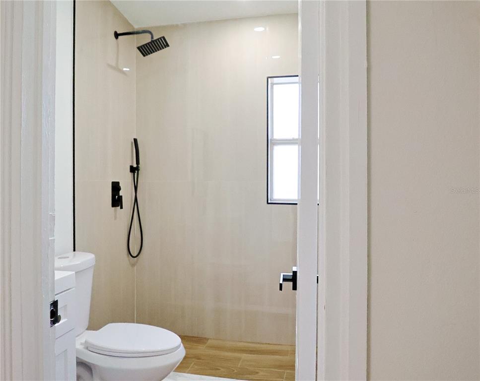 4061 Ferrow Street Orlando, FL 32811 - Photo 16 of 31 a bathroom with a granite countertop toilet and shower