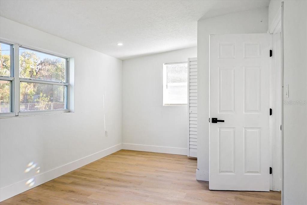 4061 Ferrow Street Orlando, FL 32811 - Photo 5 of 31 a view of an empty room with wooden floor and a window