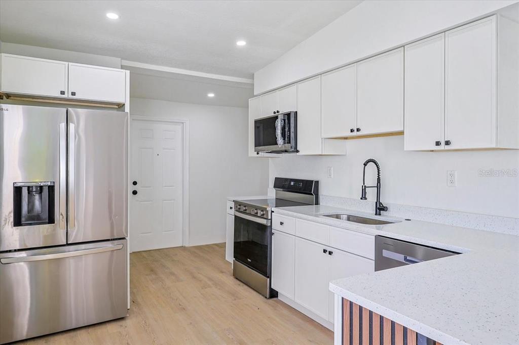 4061 Ferrow Street Orlando, FL 32811 - Photo 8 of 31 a kitchen with stainless steel appliances a refrigerator sink and microwave
