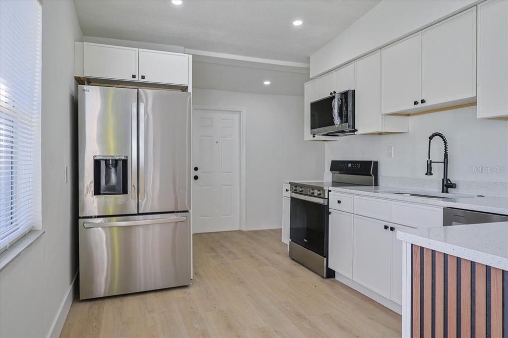 4061 Ferrow Street Orlando, FL 32811 - Photo 9 of 31 a kitchen with stainless steel appliances granite countertop a refrigerator stove a sink and a microwave