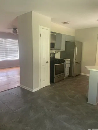 a view of a kitchen with a sink and a refrigerator