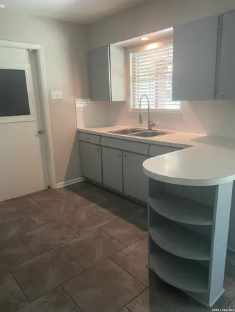 a kitchen with a sink cabinets and a window