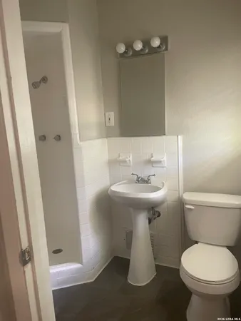 a bathroom with a sink toilet and a mirror