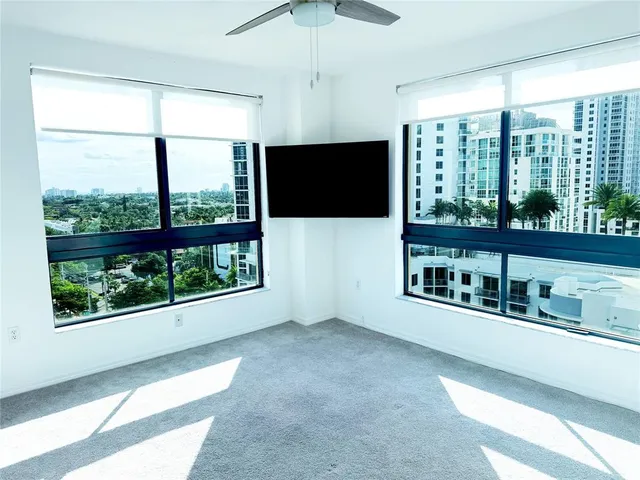 a living room with large windows and a flat screen tv