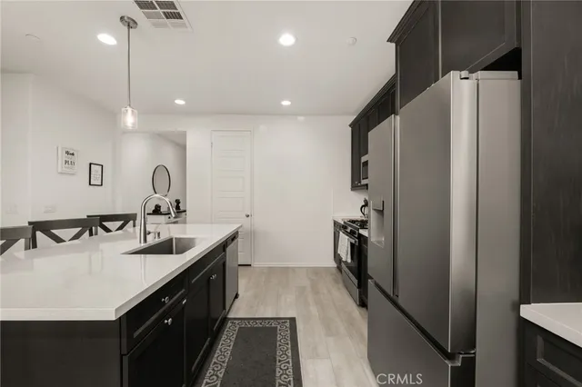 a kitchen with a sink refrigerator and cabinets
