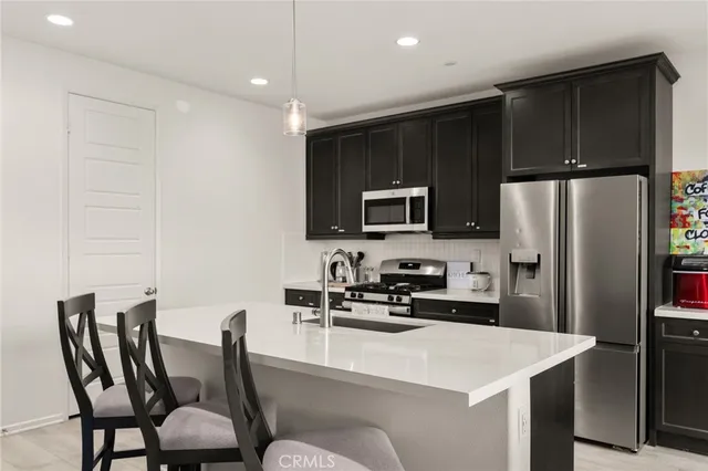 a kitchen with a table chairs refrigerator and microwave