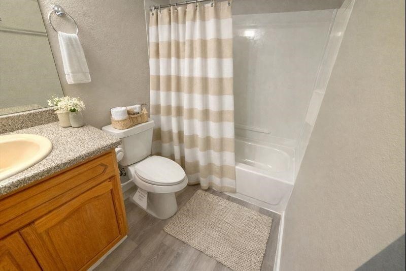 3085 Walnut Bend Lane, Unit 16 Houston, TX 77042 - Photo 6 of 13 a bathroom with a granite countertop sink toilet a mirror and shower