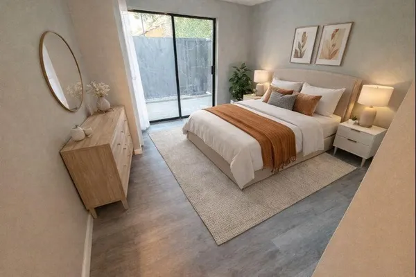 a bedroom with a bed a mirror and a large window