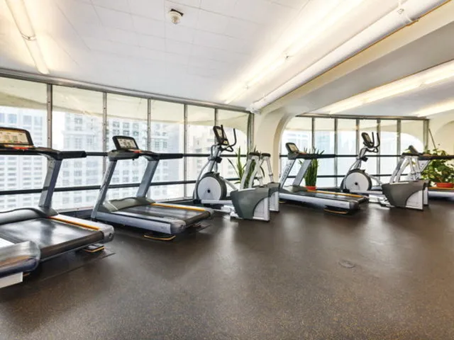 a view of a room with gym equipment and large windows