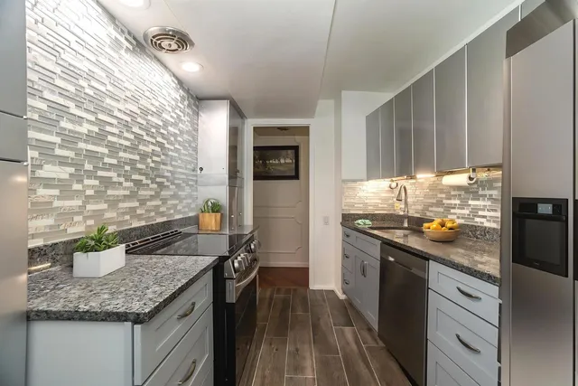 a kitchen with stainless steel appliances granite countertop a sink stove and refrigerator