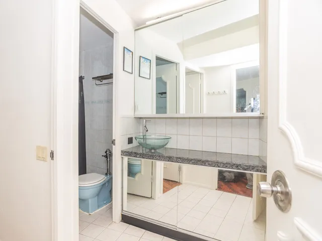 a kitchen with a sink and a stove with white cabinets