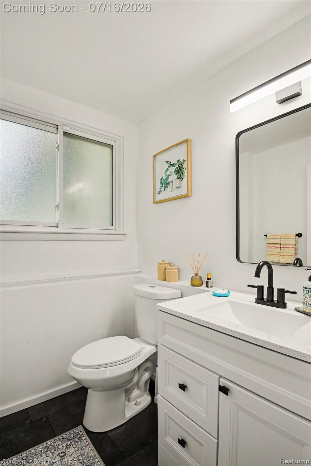 3304 Riverside Drive Port Huron, MI 48060 - Photo 14 of 26 Bathroom featuring a white vanity with black hardware, an integrated sink, and a black faucet