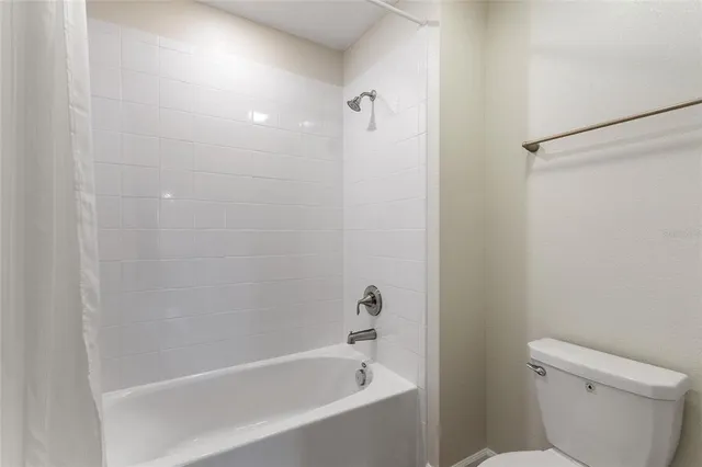 a bathroom with a granite countertop sink a toilet and a mirror