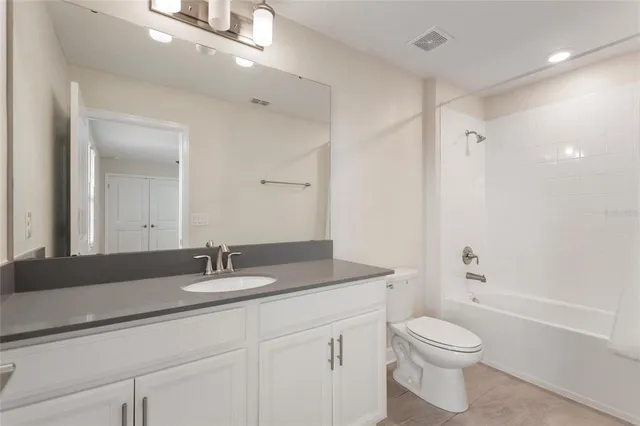 a kitchen with granite countertop white cabinets and a stove