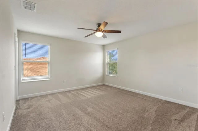 a view of an empty room with a ceiling fan