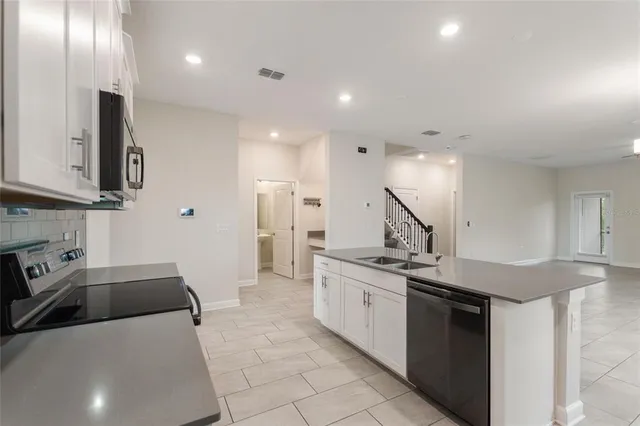 a kitchen with stainless steel appliances granite countertop a sink a stove a microwave and a refrigerator