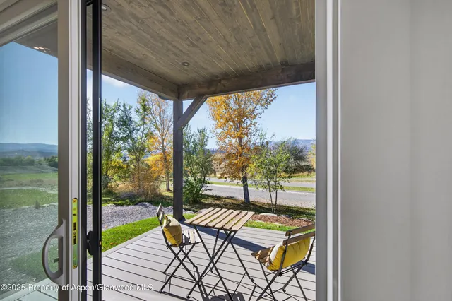 a view of a balcony with chairs and wooden floor