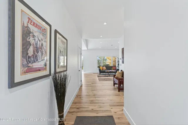 a view of a hallway with wooden floor and furniture