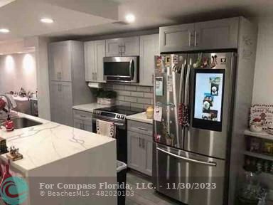 a kitchen with a refrigerator stainless steel appliances and cabinets
