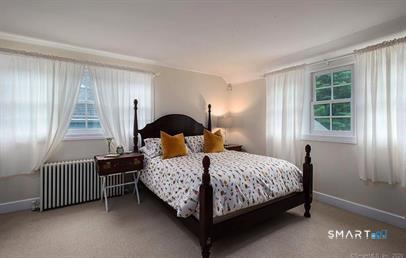 437 Hulls Farm Road Fairfield, CT 06890 - Photo 11 of 15 a bedroom with a bed chair and a window