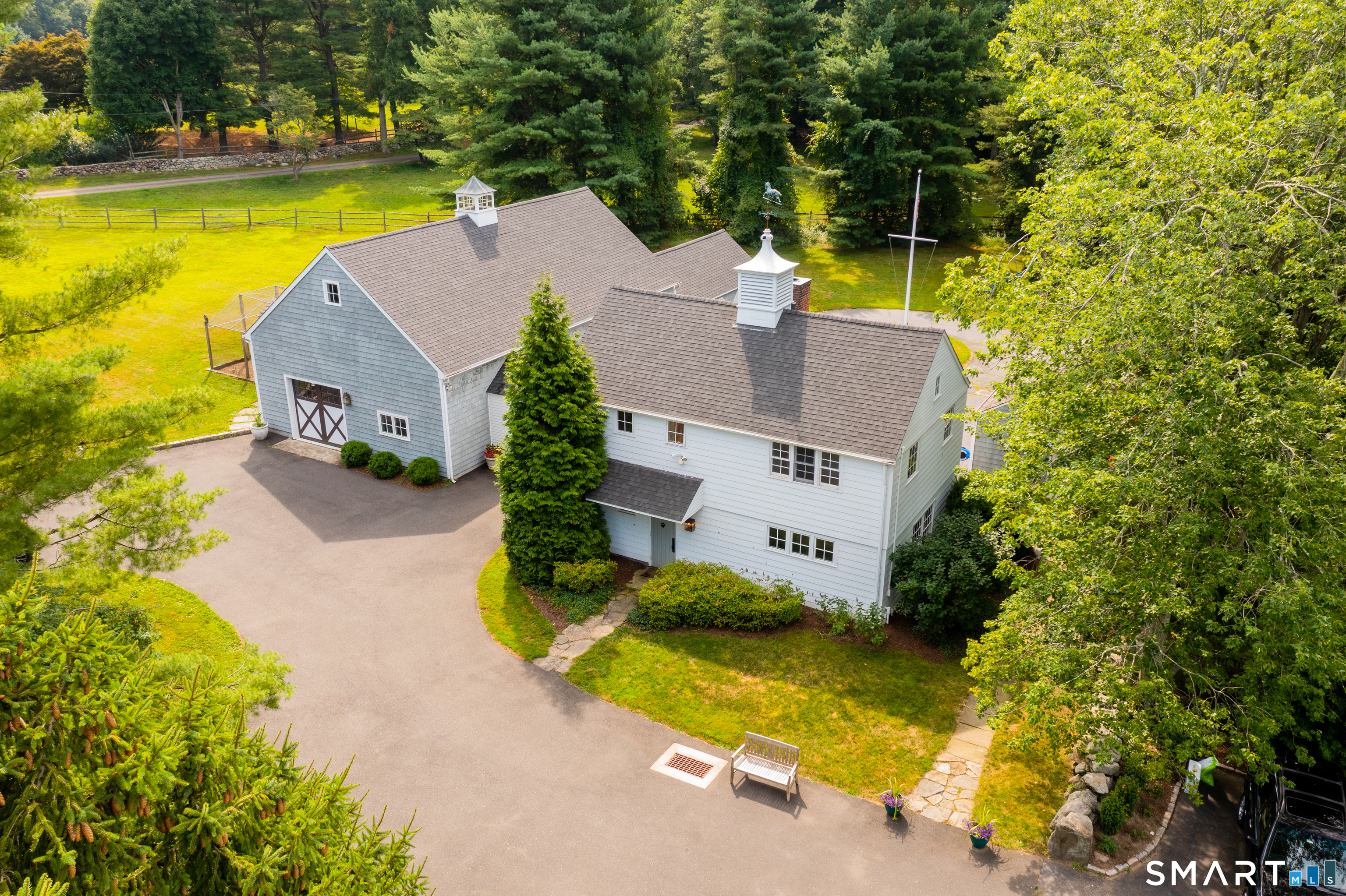 437 Hulls Farm Road Fairfield, CT 06890 - Photo 3 of 15 an aerial view of a house with swimming pool and large trees