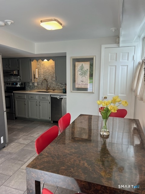 437 Hulls Farm Road Fairfield, CT 06890 - Photo 5 of 15 a kitchen with stainless steel appliances granite countertop a stove top oven