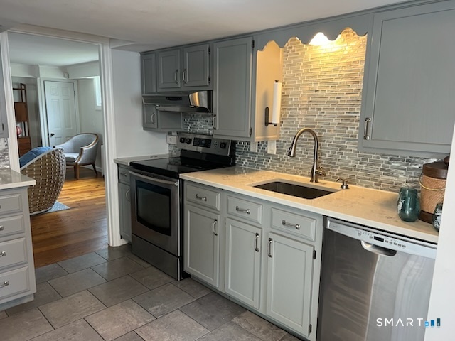 437 Hulls Farm Road Fairfield, CT 06890 - Photo 6 of 15 a kitchen with a sink stove and cabinets