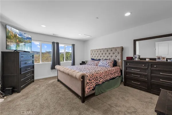 a bedroom with a bed and dresser with mirror