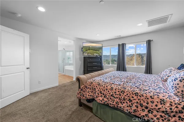 a bedroom with a large bed and dresser