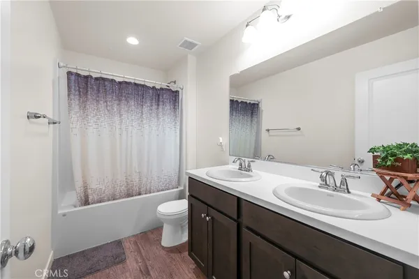 a bathroom with a double vanity sink toilet and shower