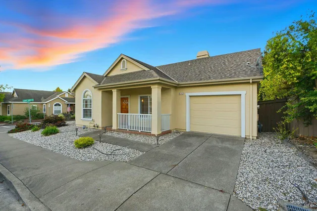 a view of a house with a yard and large tree