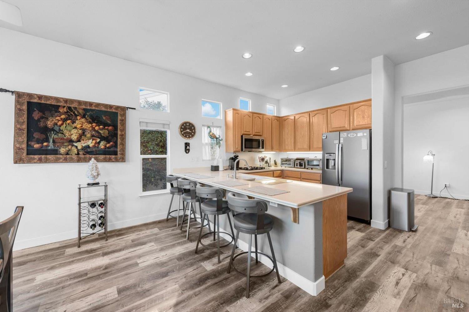 2121 St Andrews Drive Rio Vista, CA 94571 - Photo 15 of 53 a kitchen with stainless steel appliances granite countertop a refrigerator a stove a sink a dining table and chairs with wooden floor