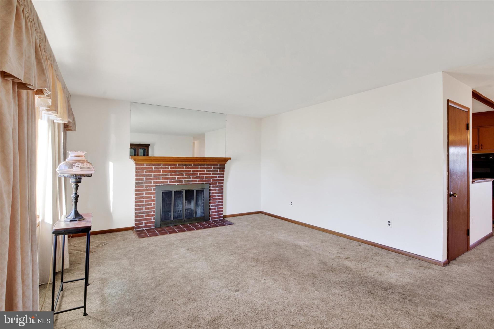 1505 Southview Road Bel Air, MD 21015 - Photo 4 of 25 an empty room with a fireplace and a window