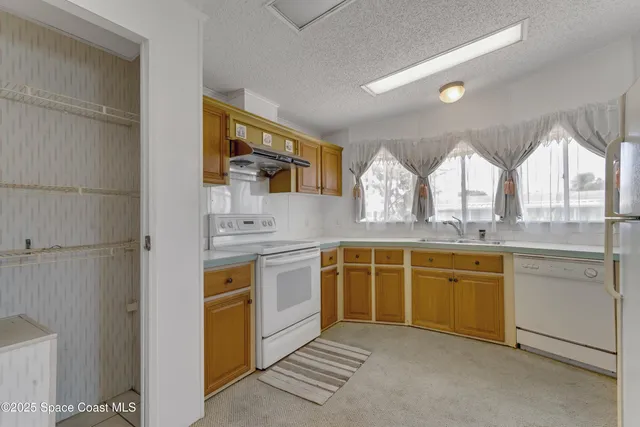 a large kitchen with stainless steel appliances granite countertop a stove a sink and a microwave