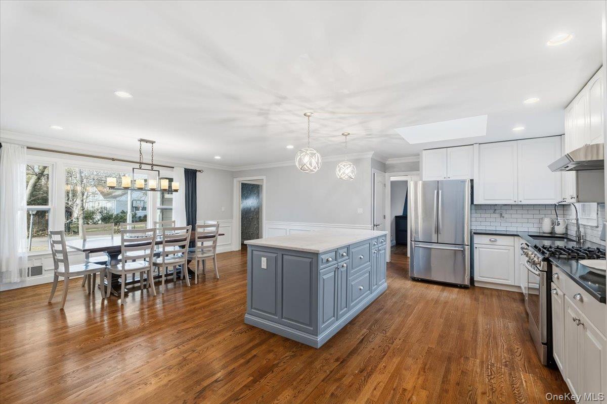 39 Darling Avenue New Rochelle, NY 10804 - Photo 3 of 19 a kitchen with stainless steel appliances granite countertop a table chairs stove and wooden floor