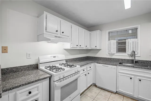 a kitchen with stainless steel appliances granite countertop a refrigerator and a stove